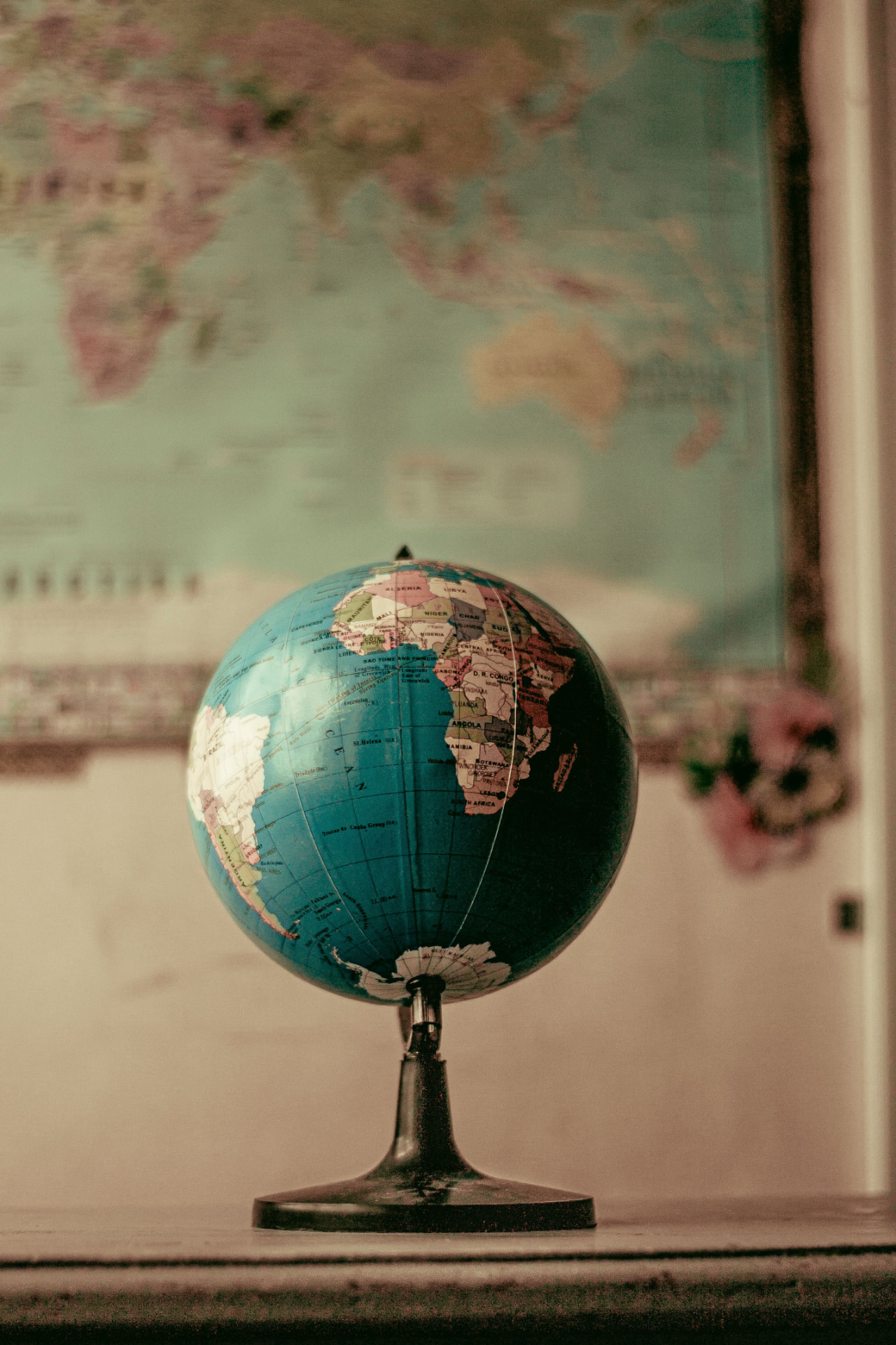 Vintage globe in front of a world map